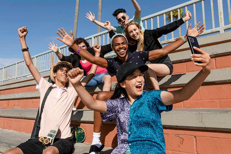Happy teens taking a group selfie.